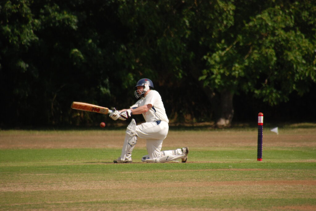 Paul Evans on one knee sweeps the ball to the leg side