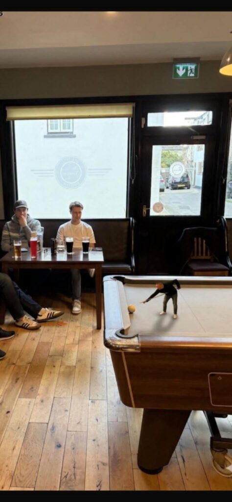 Martin has been shrunk to about 6 inches tall and is playing pool on a full size table